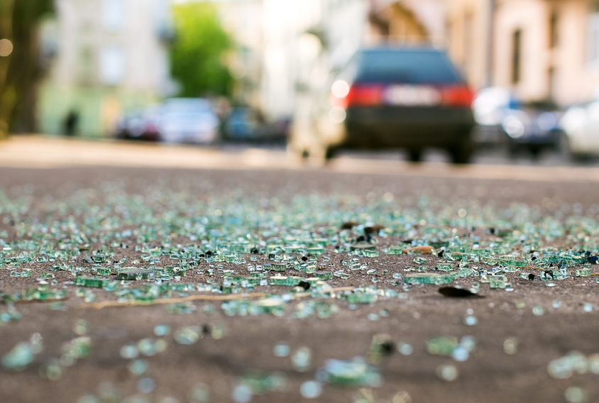 Skår av bil glass på gaten etter bilulykke
