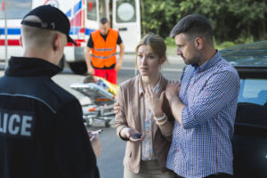 Bystanders describing the scene of an accident to the police officer