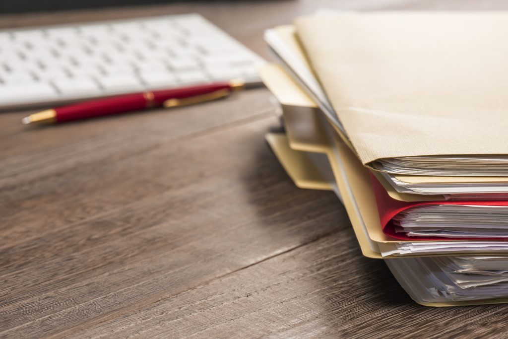 A stack of files sitting on a desk