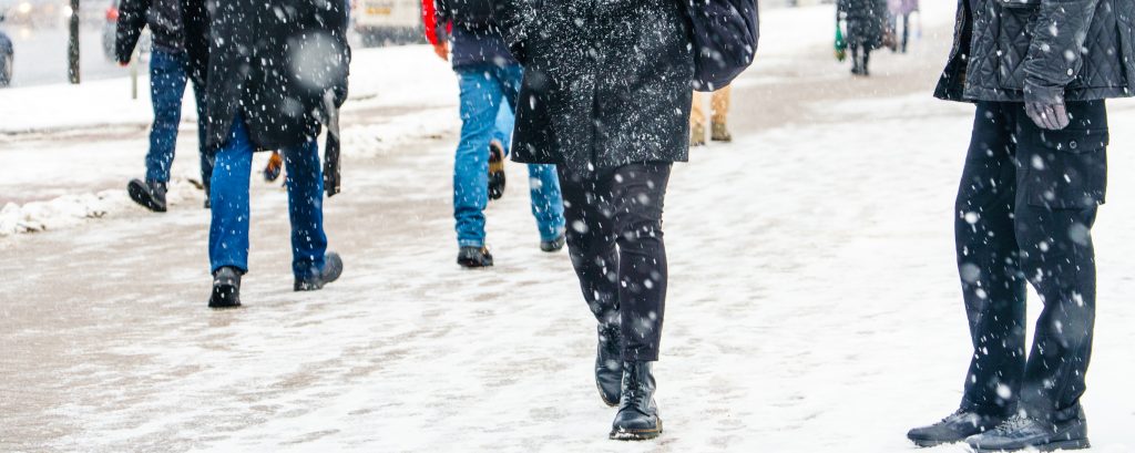 people walking on a snowy sidewalk