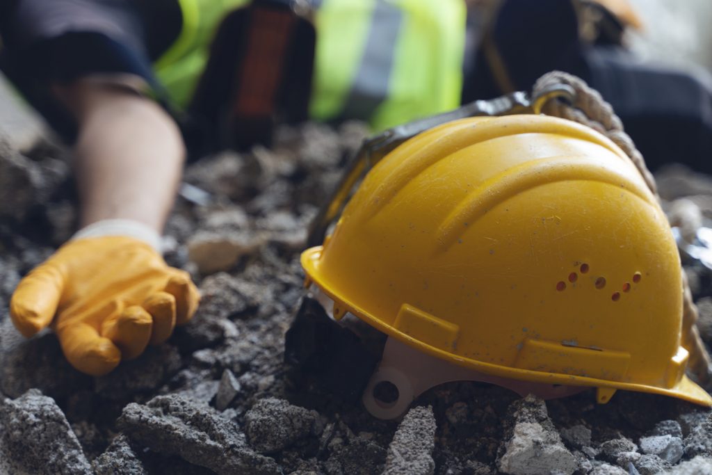 Injured construction worker next to hard hat