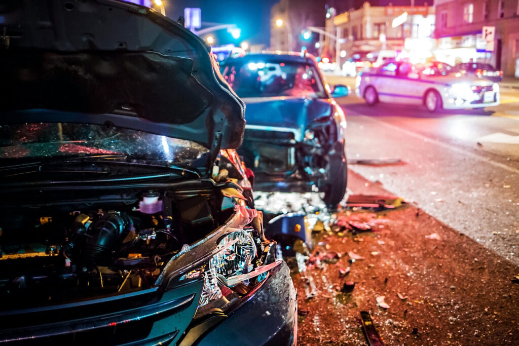 Two cars on a city street after a head-on collision