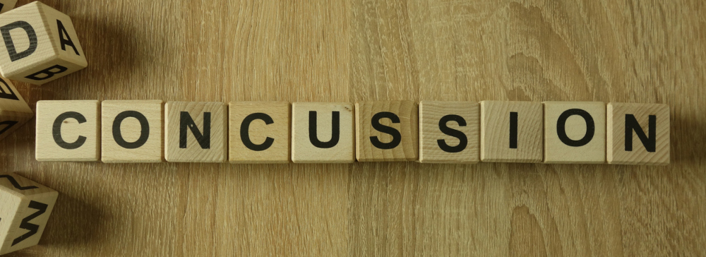 Wooden blocks on a desk spelling the word concussion